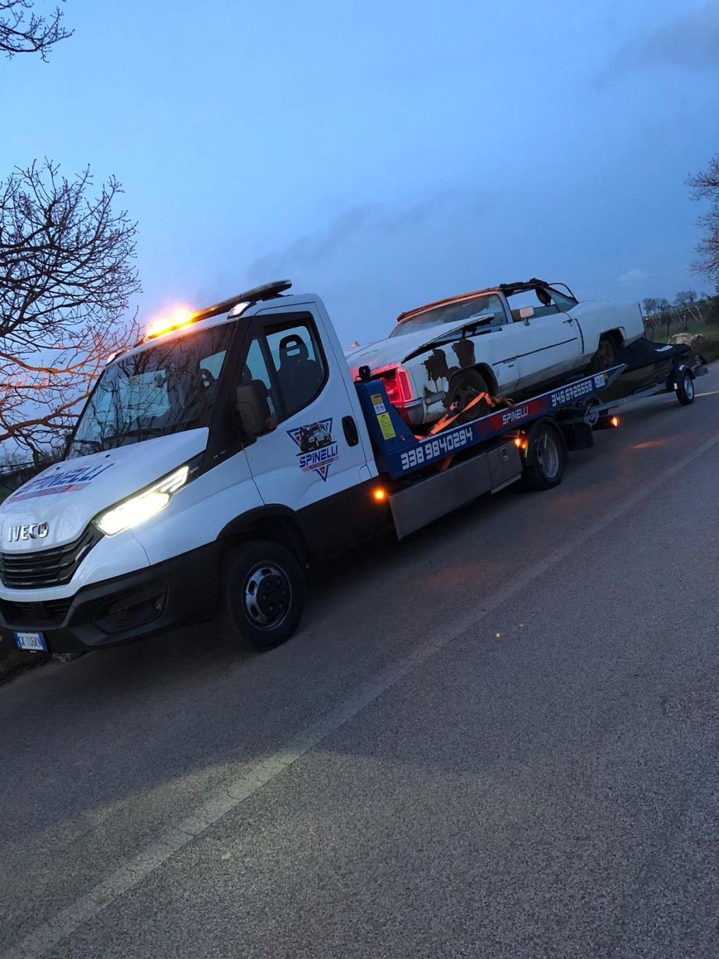 Carro attrezzi Spinelli al tramonto, con un'auto sul pianale